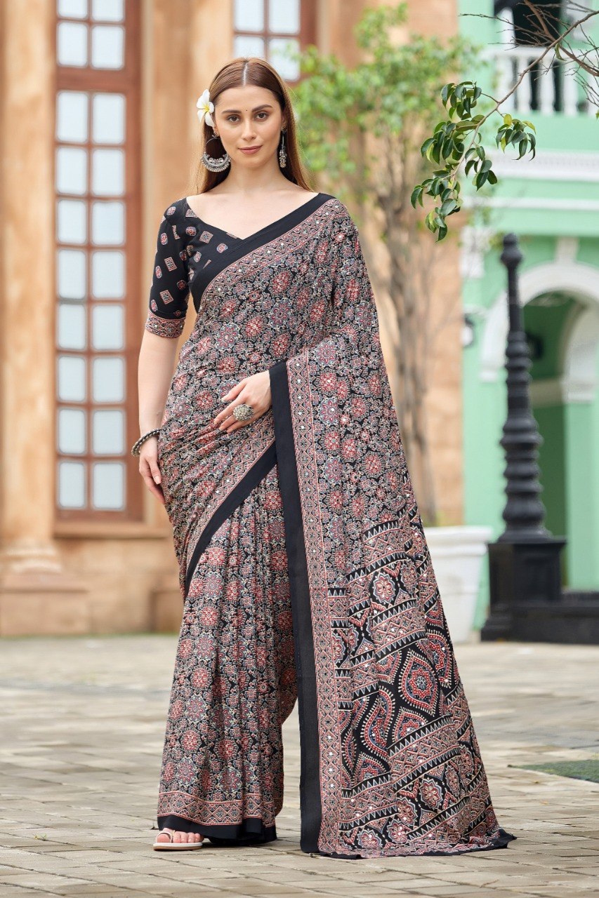 Woman wearing a black Ajrakh print mirror work Italian crepe saree with geometric border and matching blouse — Chandrikas