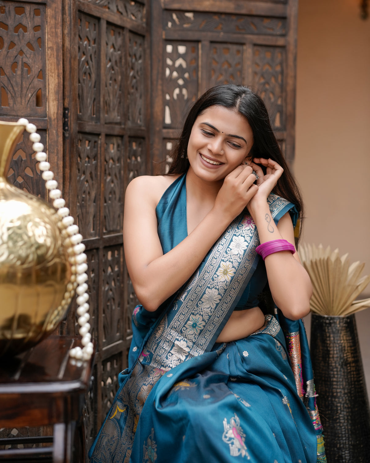 Woman in close pose wearing deep teal blue Meenakari deer motif zari pallu silk saree — Chandrikas