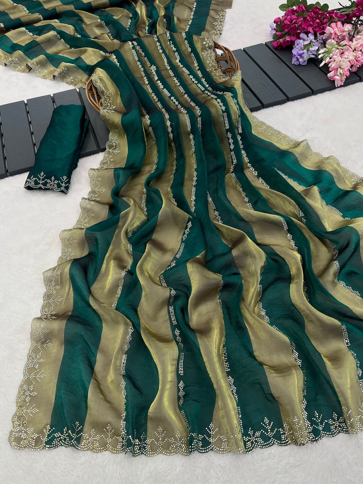 Closeup of emerald green striped satin patta saree flatlay showing golden border detail — Chandrikas