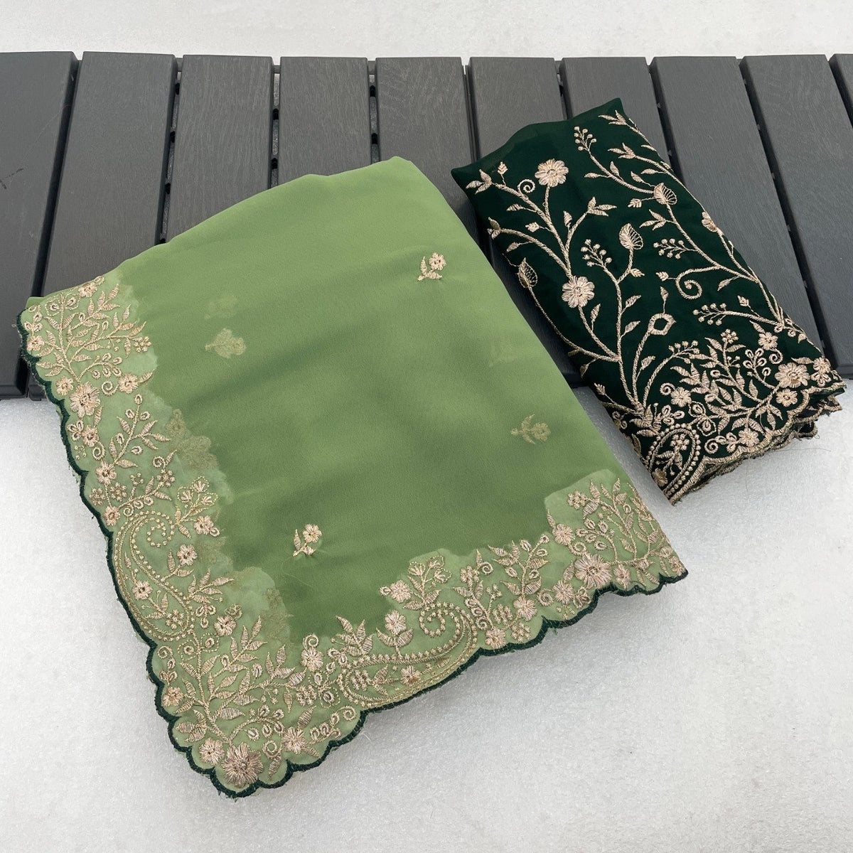 Sage green Georgette saree flatlay with floral embroidered border and matching blouse — Chandrikas