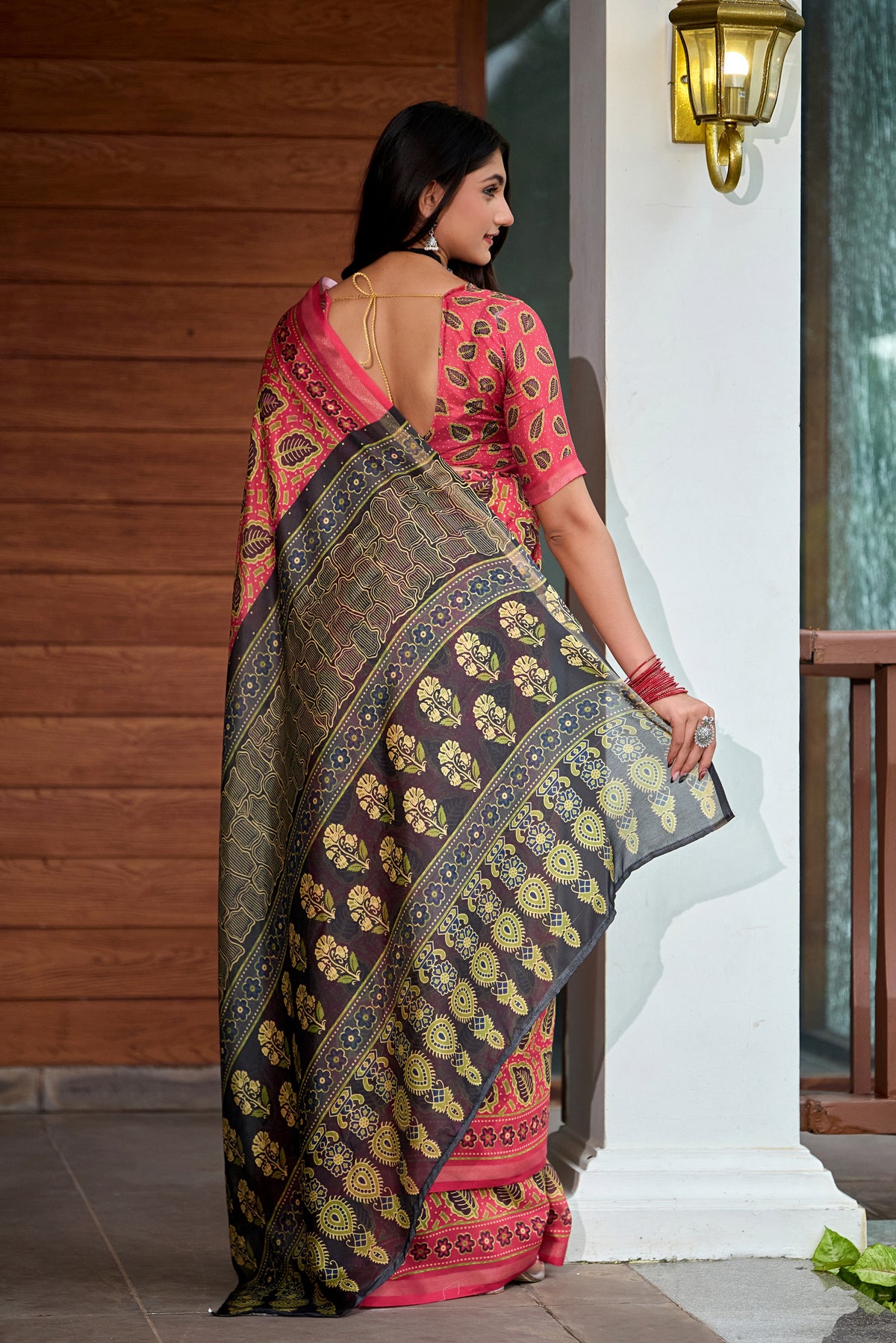Woman in side pose wearing coral red leaf print cotton saree with grey border — Chandrikas