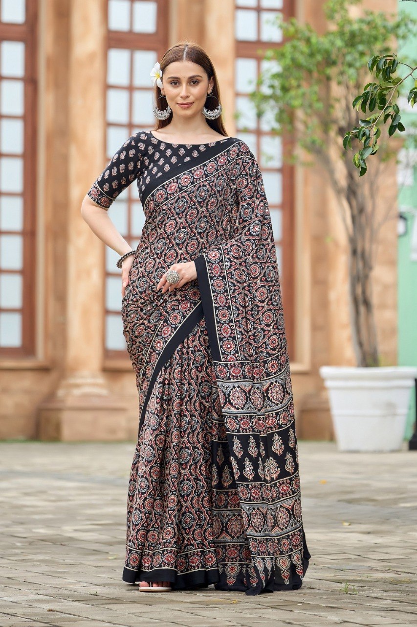 Woman wearing a black Ajrakh print mirror work Italian crepe saree with paisley border and matching blouse — Chandrikas