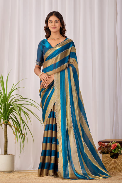 Woman in front pose wearing cobalt blue striped satin patta saree with golden border — Chandrikas
