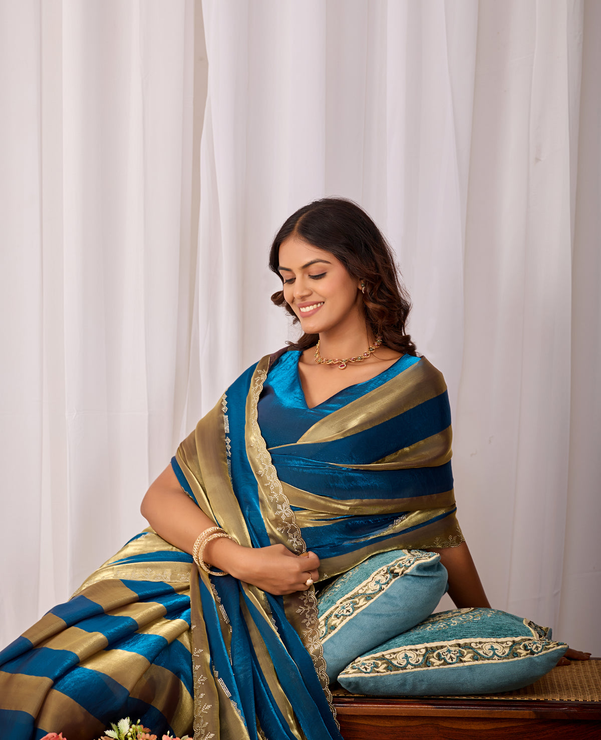 Woman in sitting pose wearing cobalt blue striped satin patta saree with golden border — Chandrikas