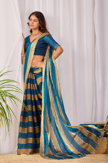 Woman in standing pose wearing cobalt blue striped satin patta saree with golden border — Chandrikas