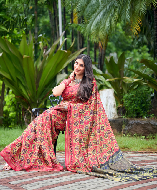 Woman in sitting pose wearing coral red leaf print cotton saree with grey border — Chandrikas
