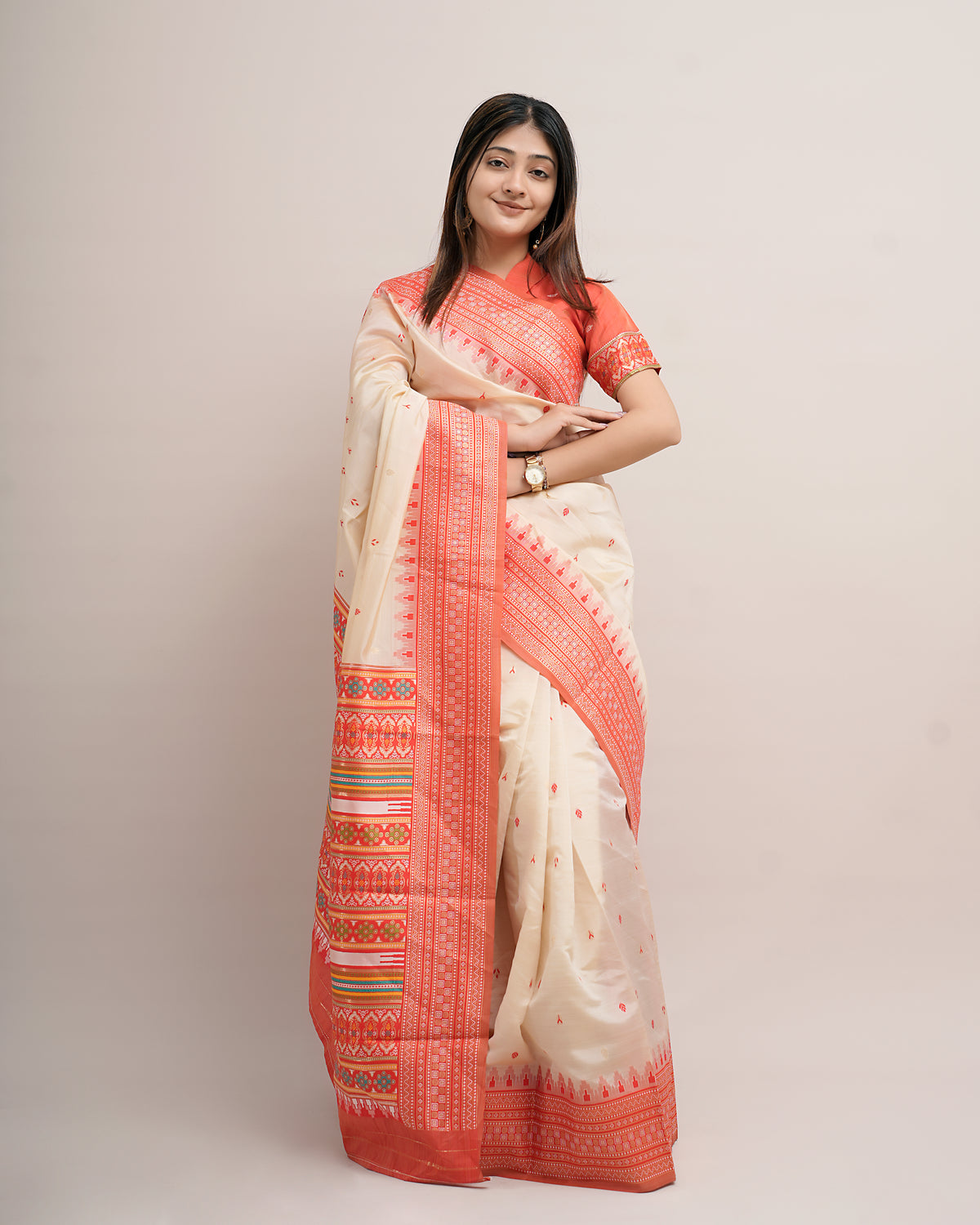 Woman in standing pose wearing cream coral Assam cotton silk saree with temple border — Chandrikas