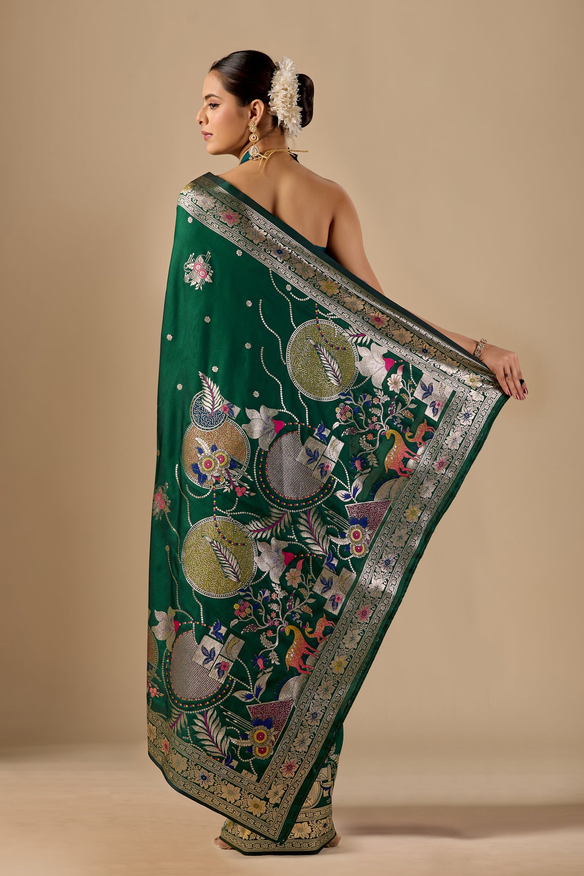 Woman draping deep green Meenakari deer motif zari pallu silk saree showing pallu design — Chandrikas