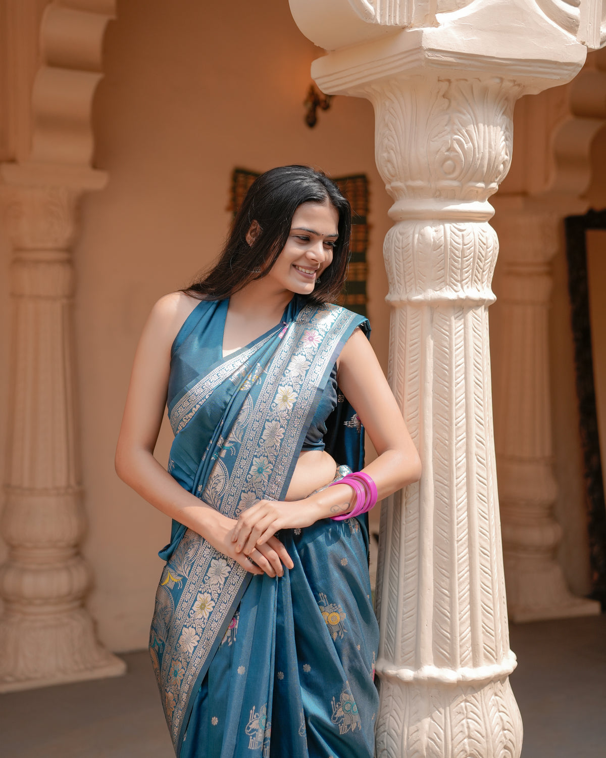 Woman in side pose wearing deep teal blue Meenakari deer motif zari pallu silk saree — Chandrikas