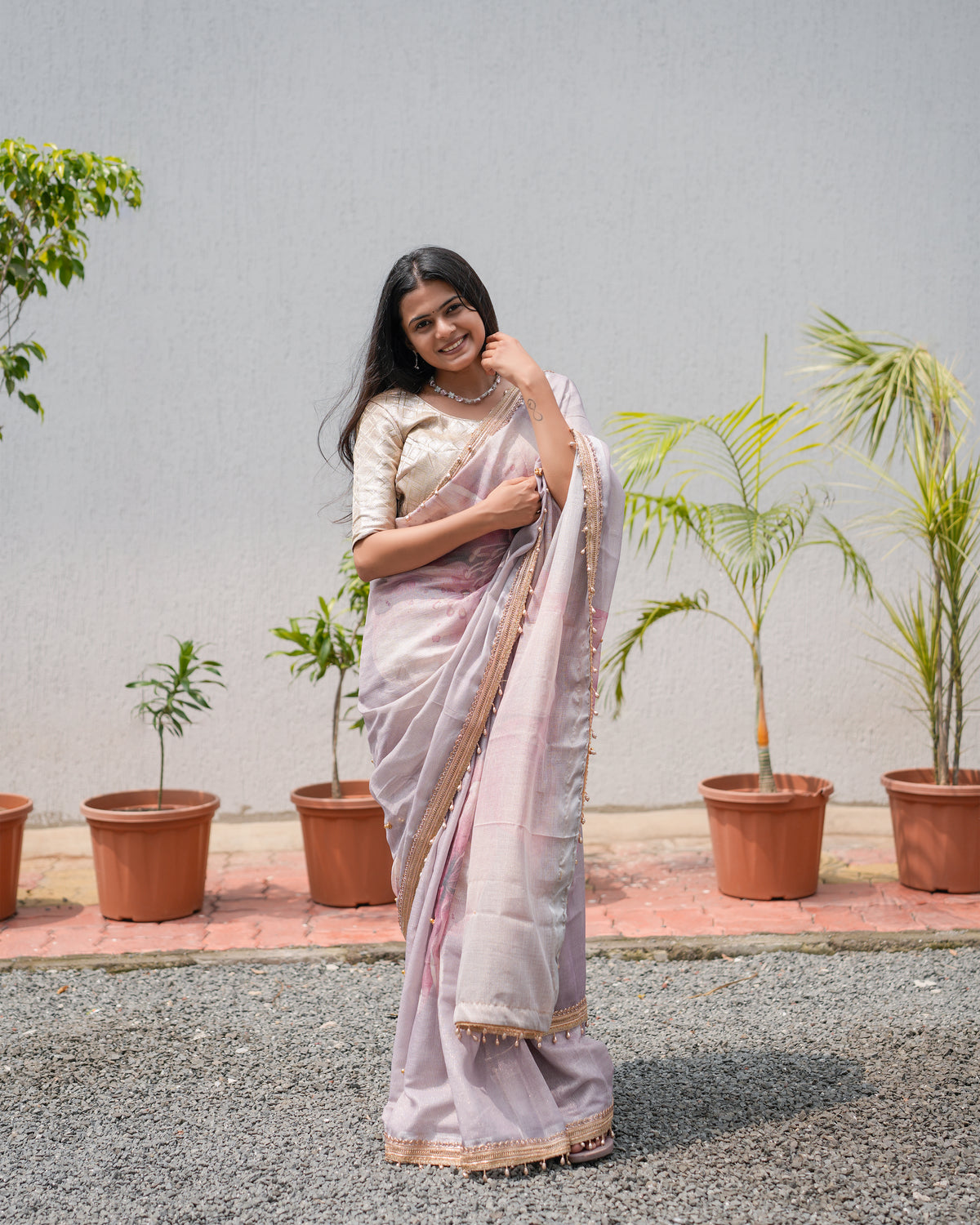Woman in side standing pose wearing dusty lavender pink tissue cotton zari saree with zari border — Chandrikas