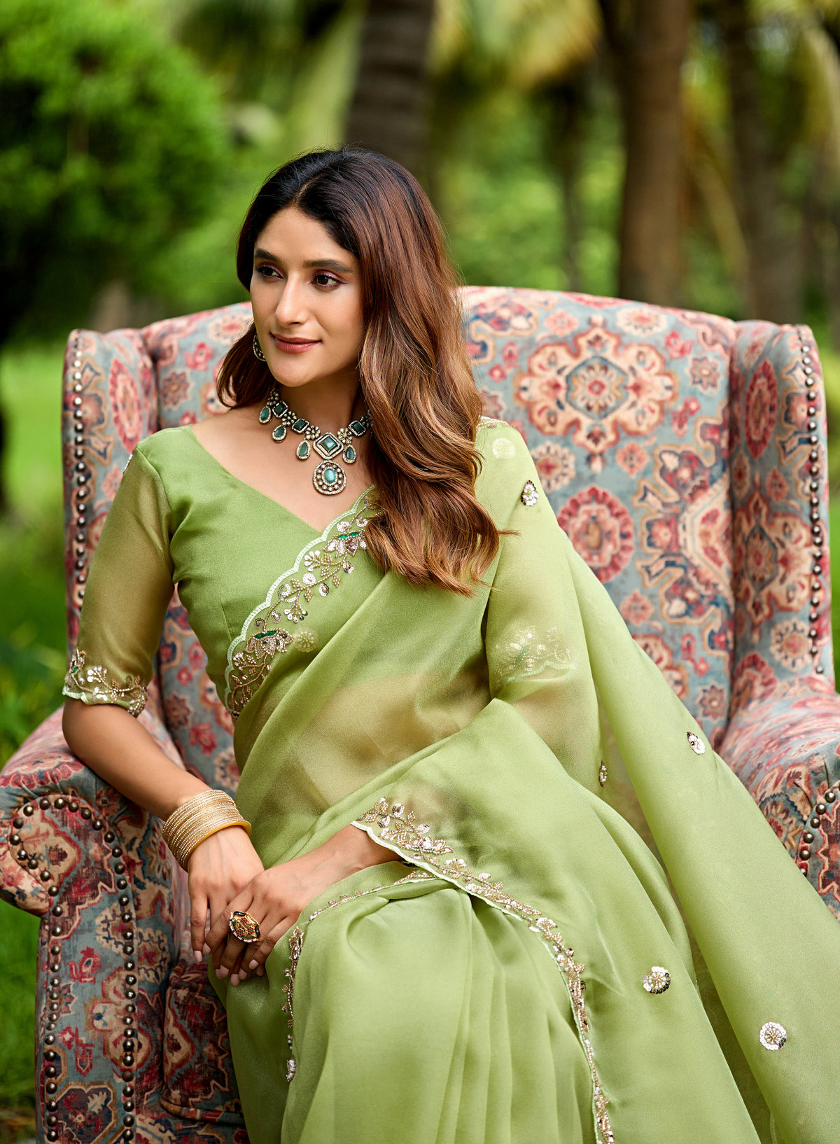 Woman in sitting pose wearing dusty pista sequin floral embroidered tissue silk saree — Chandrikas