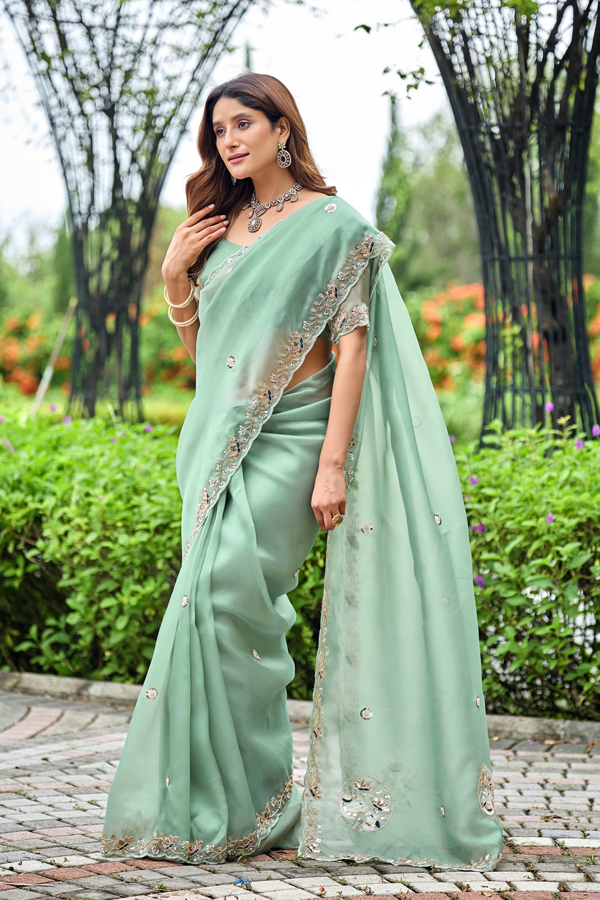 Woman in side pose wearing dusty rama sequin floral embroidered tissue silk saree with border — Chandrikas