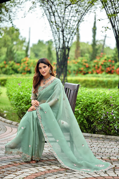 Woman in sitting pose wearing dusty rama sequin floral embroidered tissue silk saree — Chandrikas