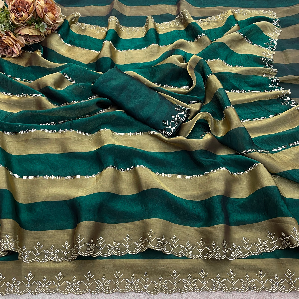 Emerald green striped satin patta saree flatlay with golden border and embellished edge — Chandrikas