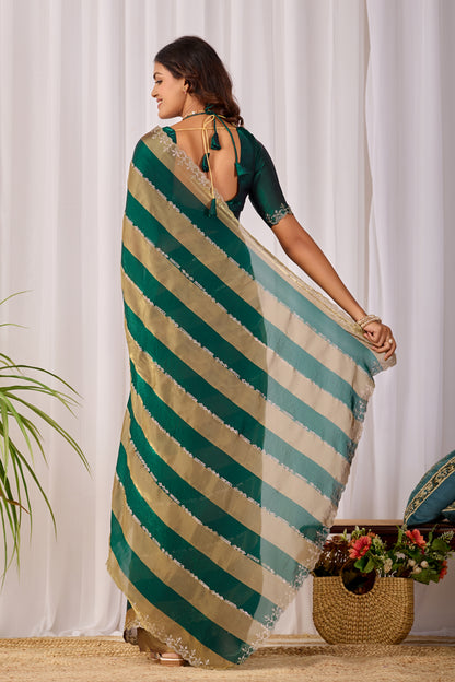 Woman in back pose wearing emerald green striped satin patta saree with golden border — Chandrikas