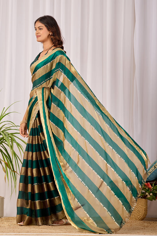 Woman in side pose wearing emerald green striped satin patta saree with golden border — Chandrikas
