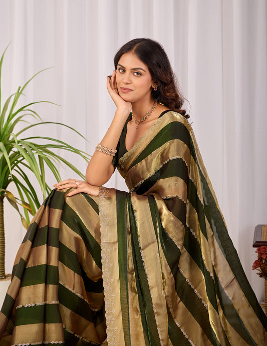 Woman in sitting pose wearing fern green striped satin patta saree with golden border — Chandrikas