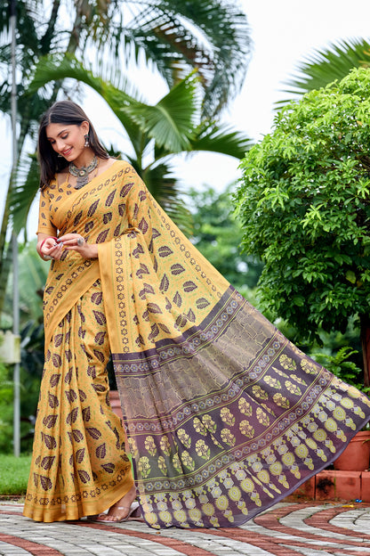 Woman in side pose wearing golden mustard leaf print cotton saree with brown border — Chandrikas