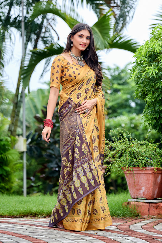 Woman in standing pose wearing golden mustard leaf print cotton saree with brown pallu — Chandrikas