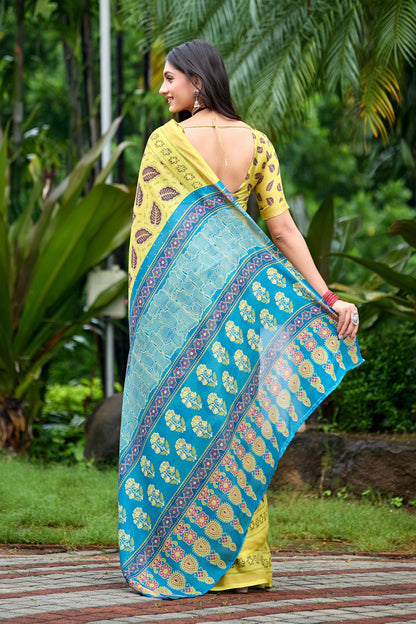 Woman in back pose wearing lemon yellow leaf print cotton saree with blue border — Chandrikas
