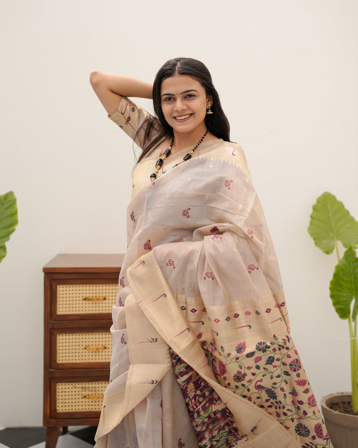 Woman draping light beige Banarasi-Paithani Meenakari cotton zari pallu saree showing peacock motif — Chandrikas