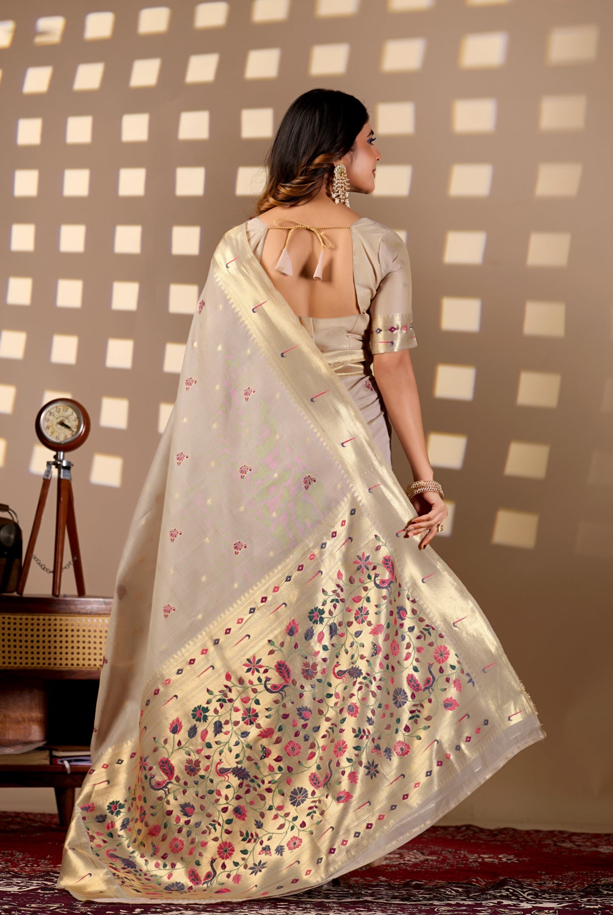 Woman draping light beige Banarasi-Paithani Meenakari cotton zari pallu saree showing peacock motif — Chandrikas