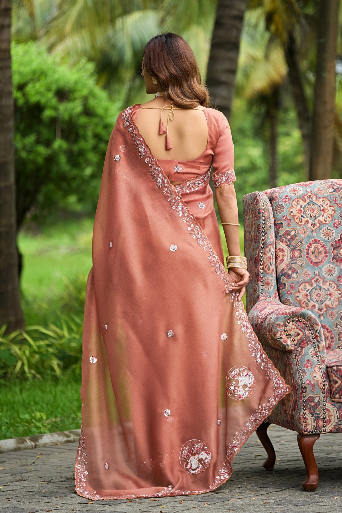 Woman in back pose wearing light gajri sequin floral embroidered tissue silk saree showing pallu — Chandrikas