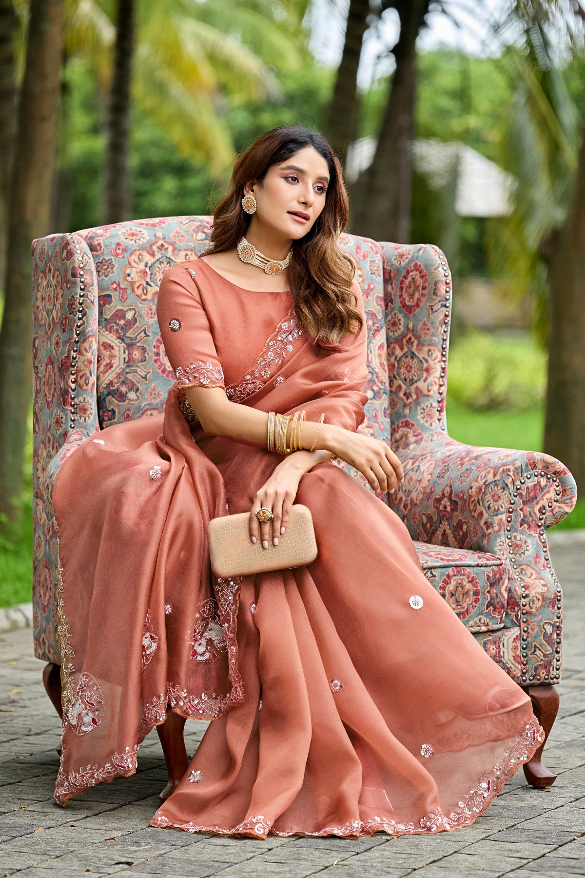 Woman in sitting pose wearing light gajri sequin floral embroidered tissue silk saree — Chandrikas