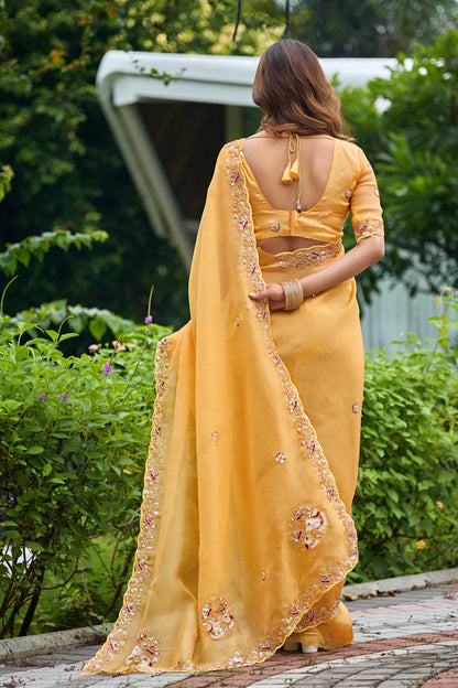 Woman in back pose wearing light yellow sequin floral embroidered tissue silk saree showing pallu — Chandrikas