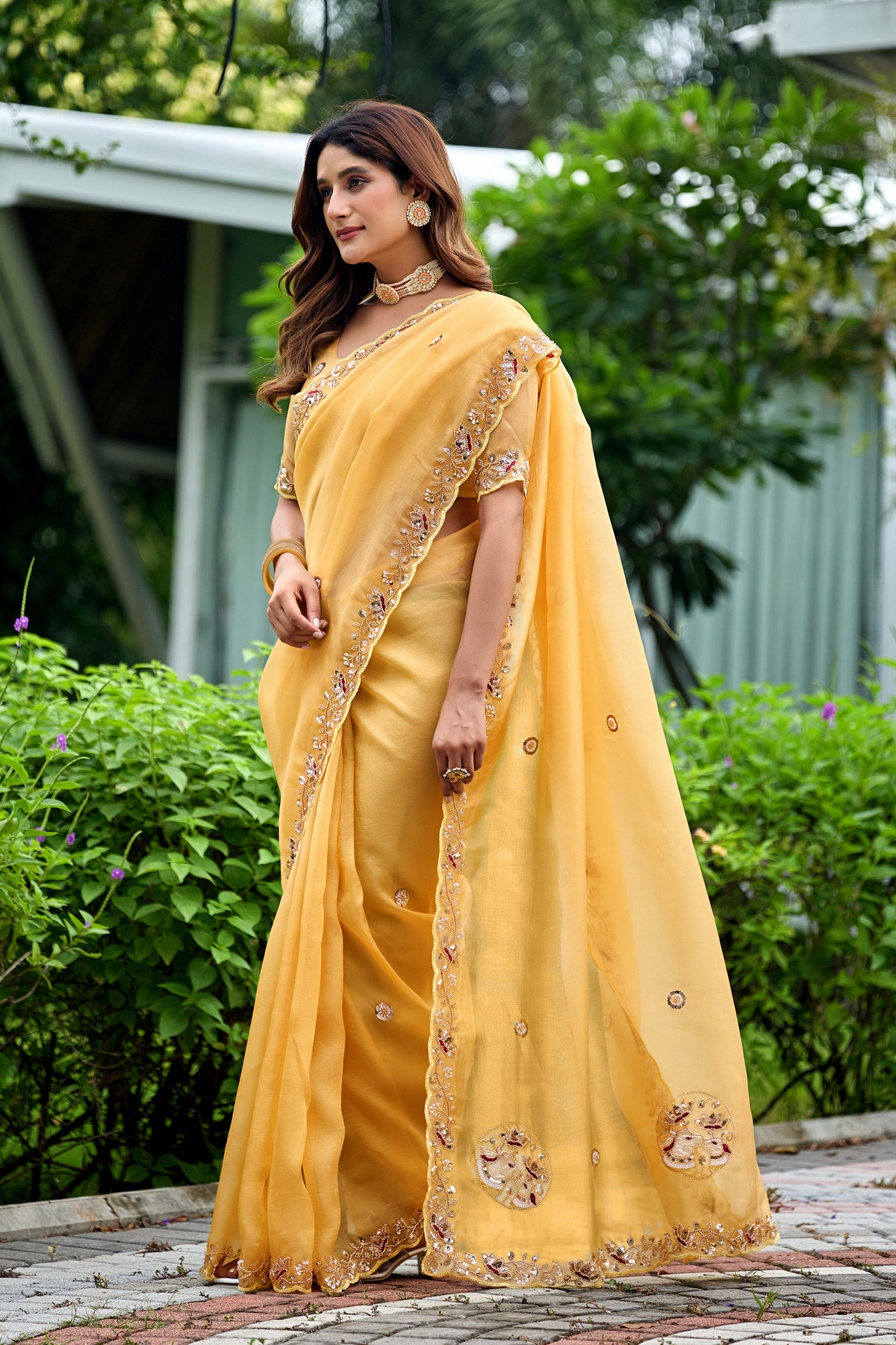 Woman in side pose wearing light yellow sequin floral embroidered tissue silk saree with border — Chandrikas