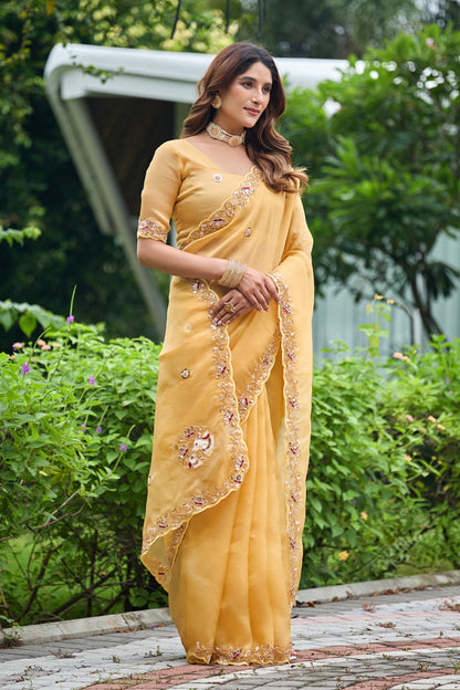 Woman in standing pose wearing light yellow sequin floral embroidered tissue silk saree with border — Chandrikas