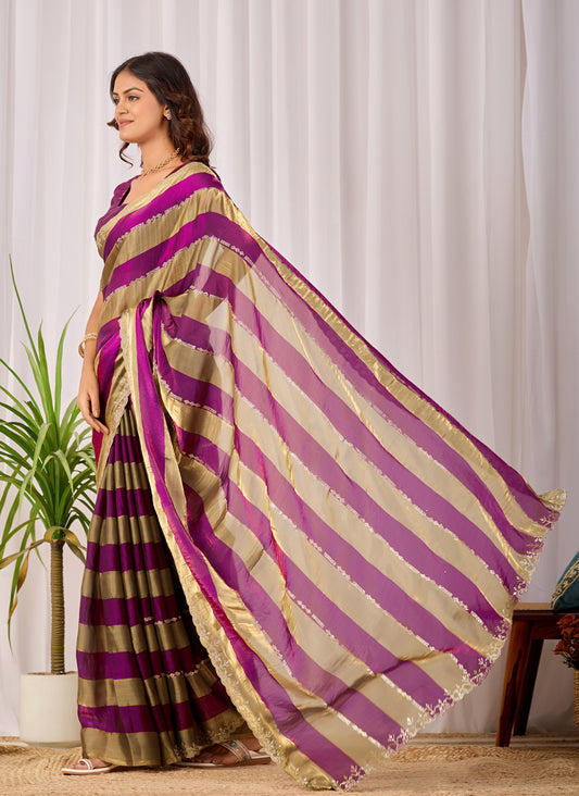 Woman in side pose wearing magenta purple striped satin patta saree with golden border — Chandrikas