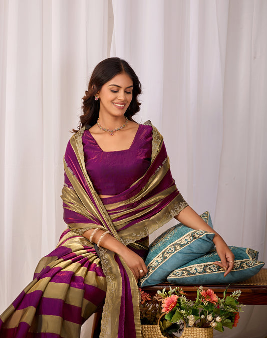 Woman in sitting pose wearing magenta purple striped satin patta saree with golden border — Chandrikas
