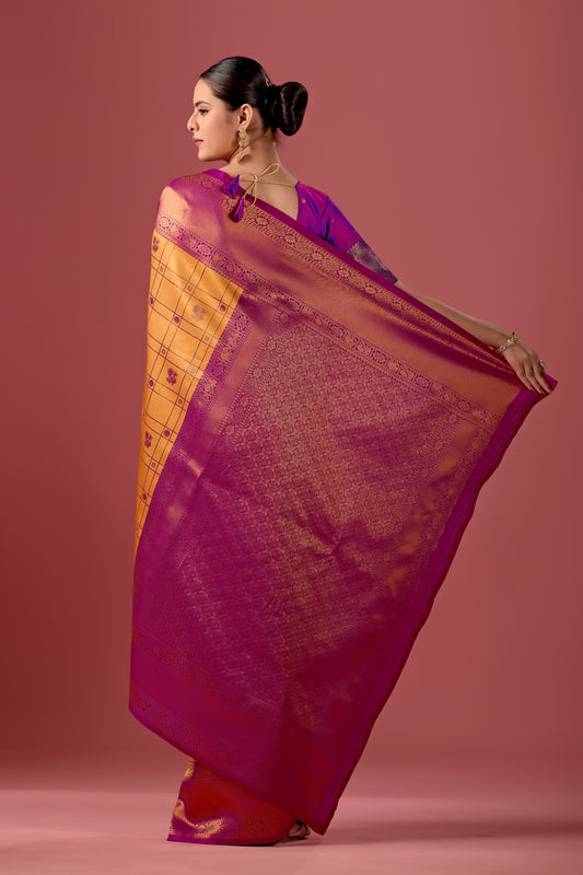 Woman draping mango yellow pink Banarasi silk checks pattern saree showing pallu design — Chandrikas