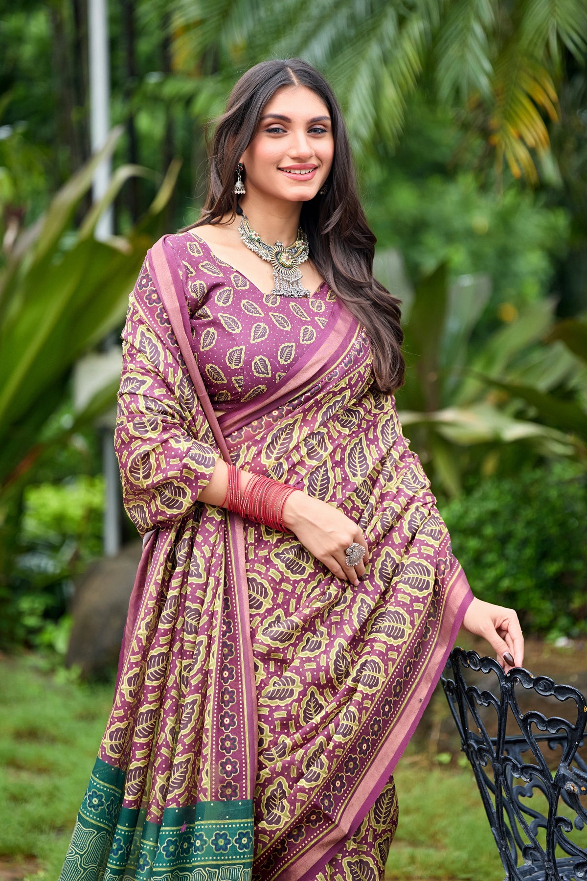 Woman in standing pose wearing mauve purple leaf print cotton saree with teal pallu — Chandrika