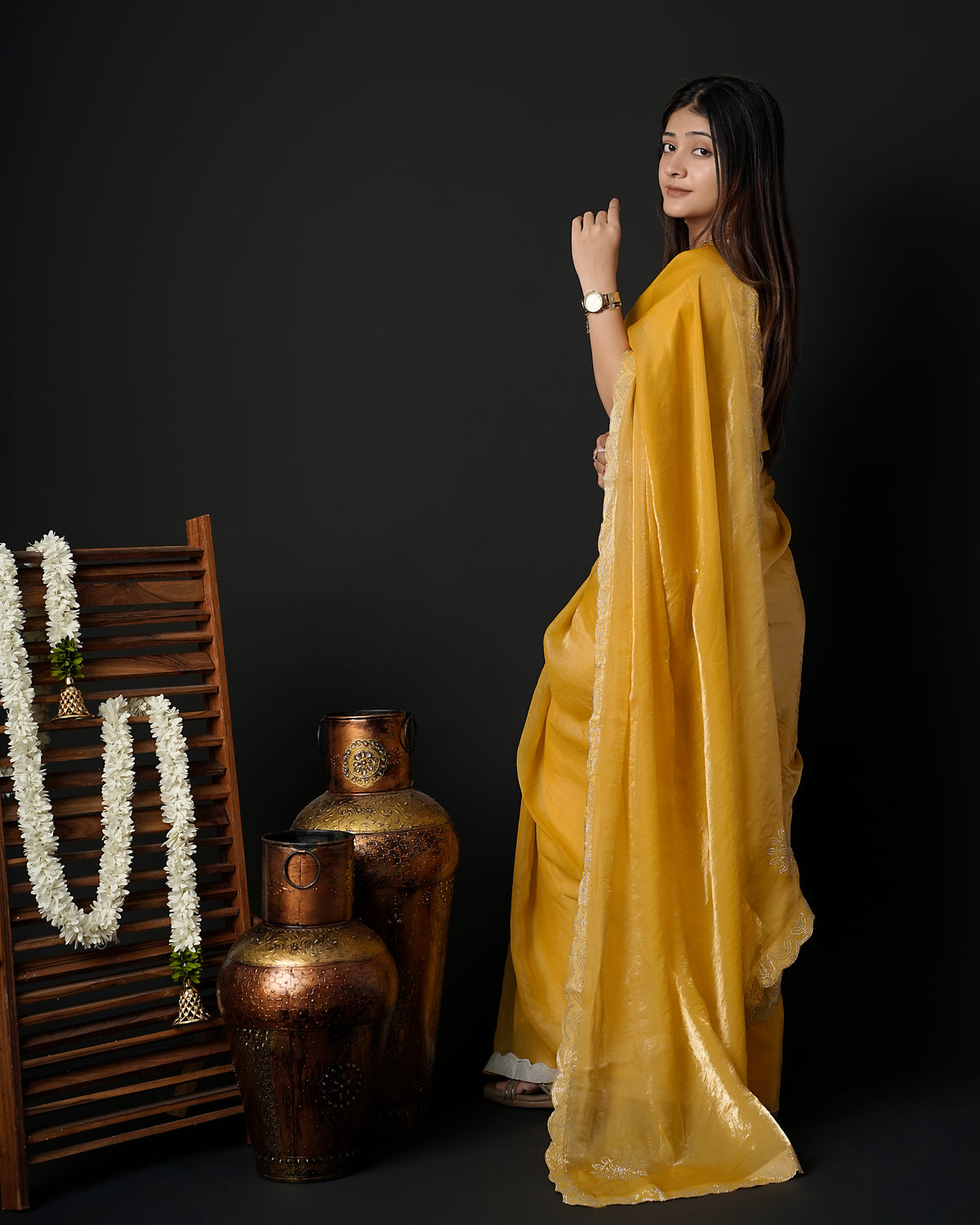 Woman in side pose wearing mustard yellow tissue crepe silk saree with scalloped border — Chandrikas