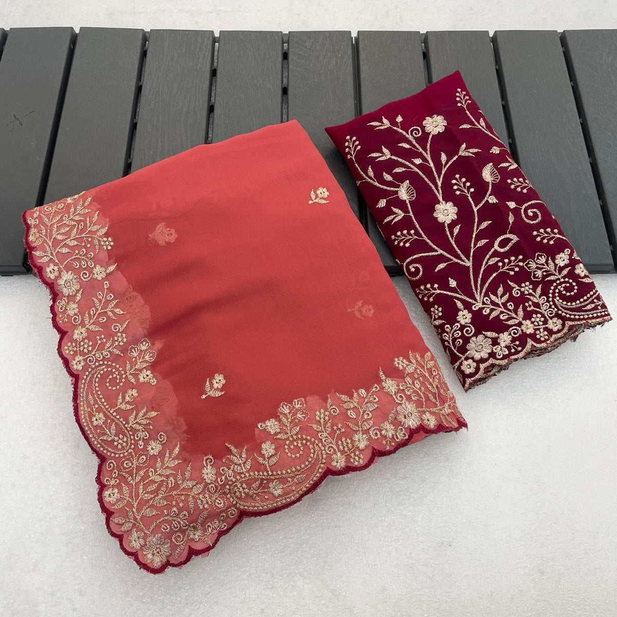 Peach coral Georgette saree flatlay with floral embroidered border and matching blouse — Chandrikas
