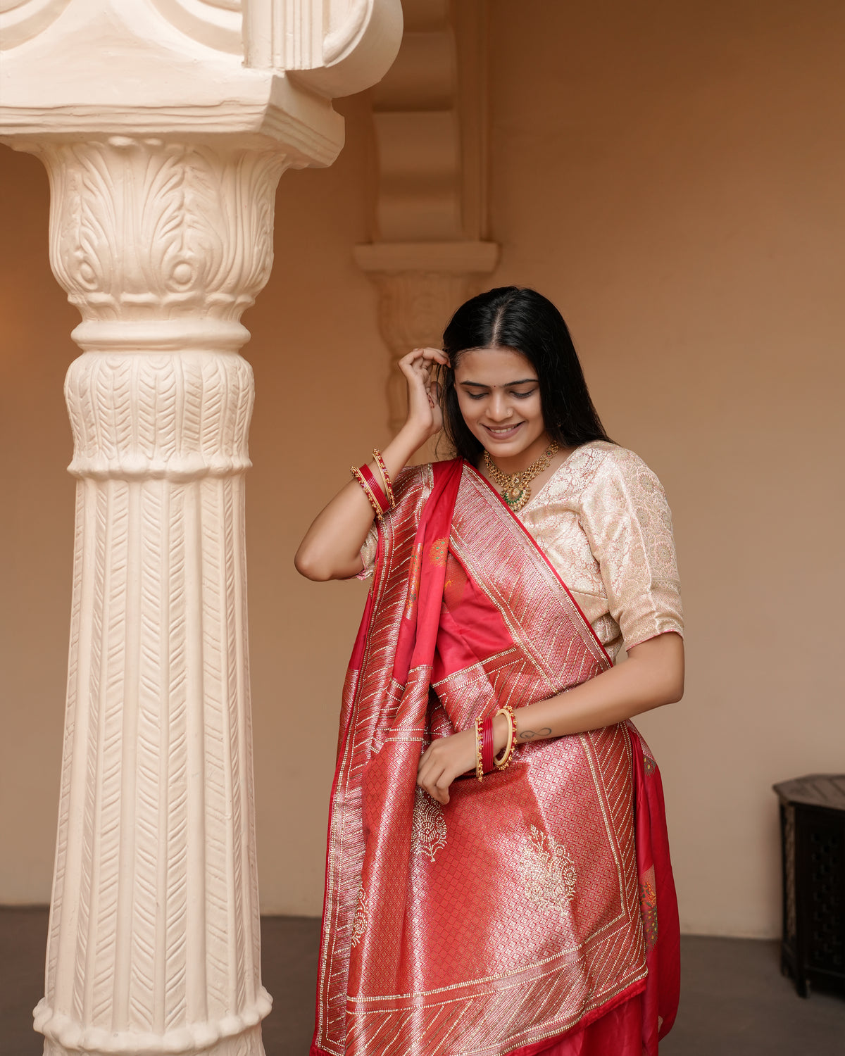 Woman in side pose wearing red Banarasi silk Jharkan work diamond jaal saree — Chandrikas