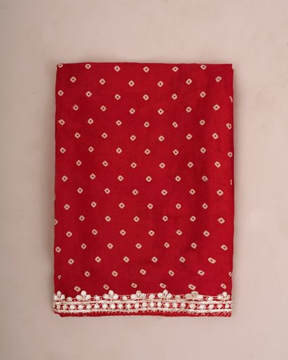 Close-up of folded red Bandhani saree fabric with gota patti lace border — Chandrikas