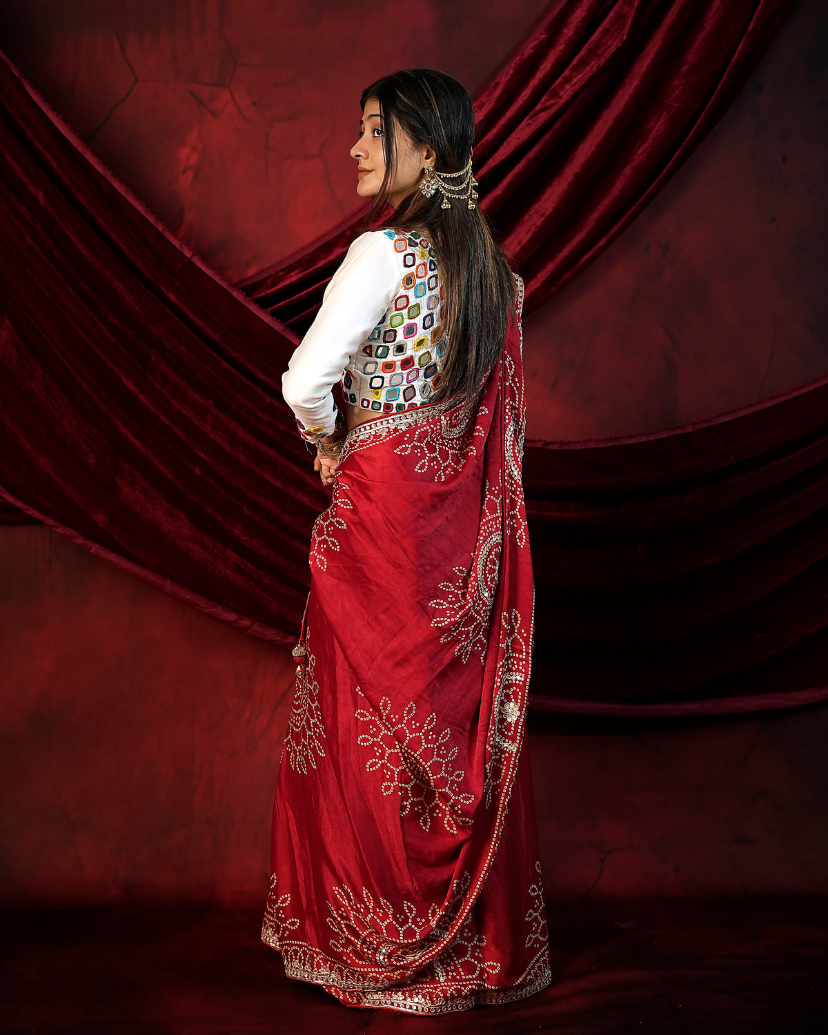 Woman in side pose wearing red Bandhani saree with Gota Patti zari border — Chandrikas