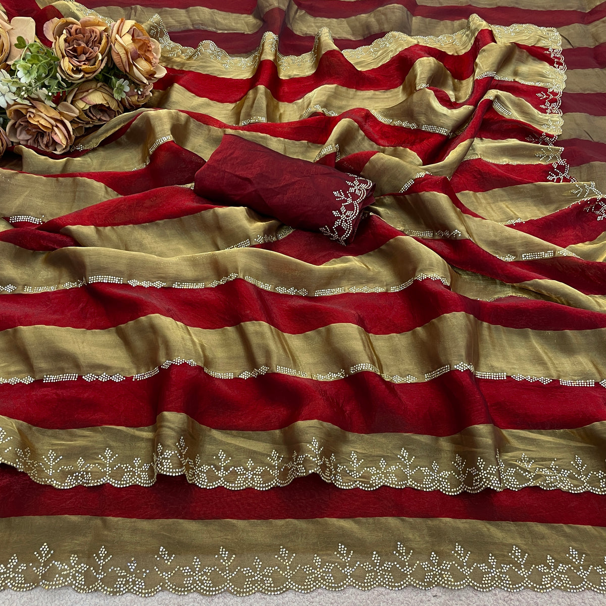 Closeup of red striped satin patta saree flatlay showing golden border detail — Chandrikas