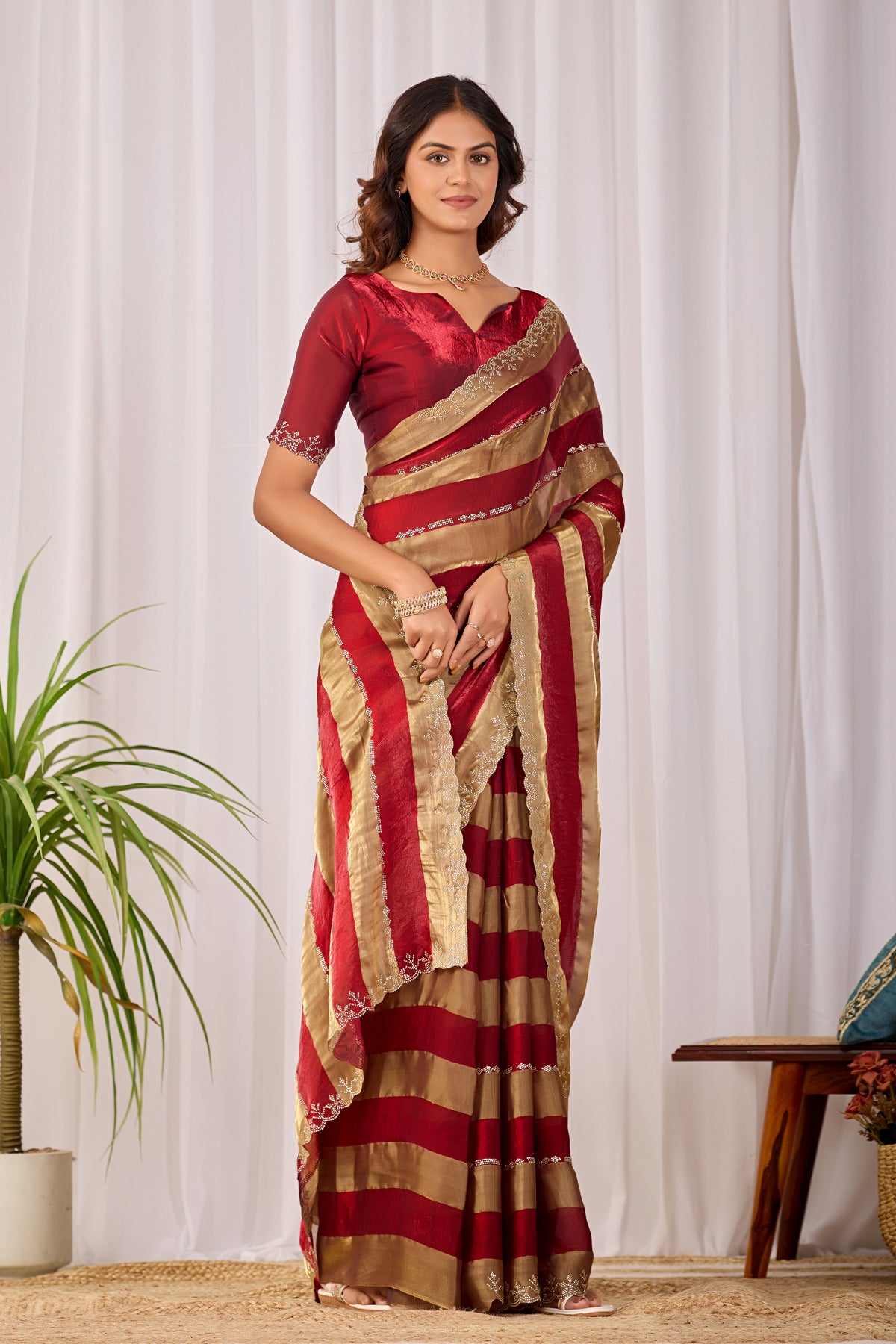 Woman in standing pose wearing red striped satin patta saree with golden border — Chandrikas