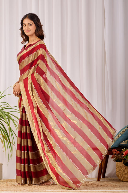 Woman walking gracefully in red striped satin patta saree with golden border — Chandrikas
