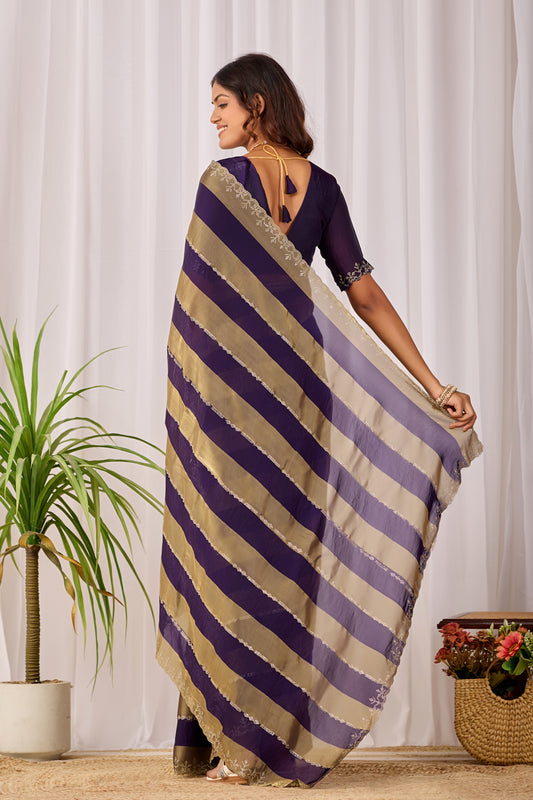 Woman in back pose wearing royal purple striped satin patta saree with golden border — Chandrikas