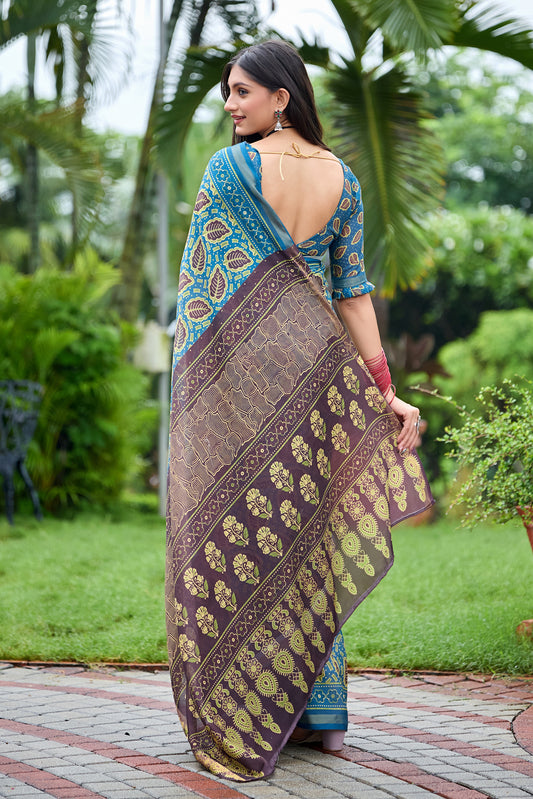 Woman in back pose wearing teal blue leaf print cotton saree with brown border — Chandrikas