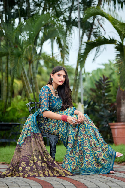 Woman in sitting pose wearing teal blue leaf print cotton saree with brown border — Chandrikas
