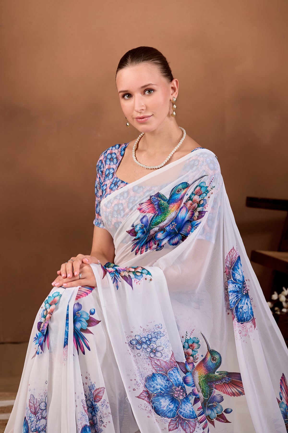 Seated close pose showing pallu and bird motif of White Navy Blue floral bird printed weightless saree — Chandrikas