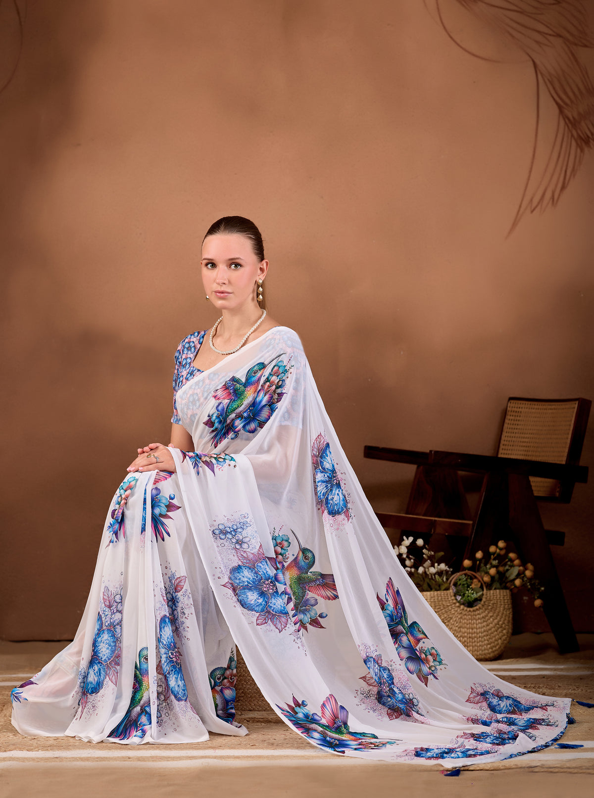 Seated pose showing flowing drape of White Navy Blue floral bird printed weightless saree — Chandrikas